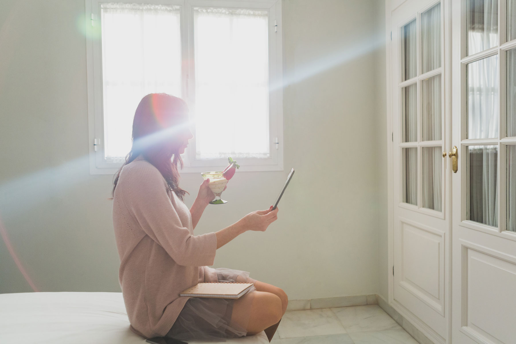 Mujer disfrutando cóctel en hogar confortable con luz natura