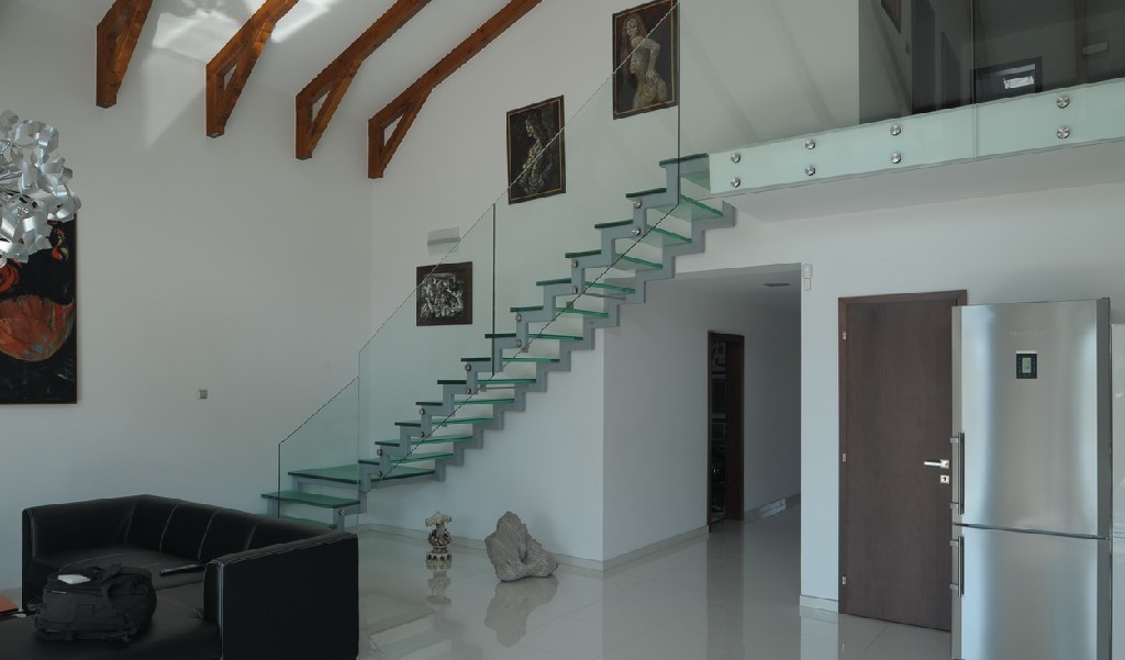 Escalera de vidrio moderna en salón con luz natural