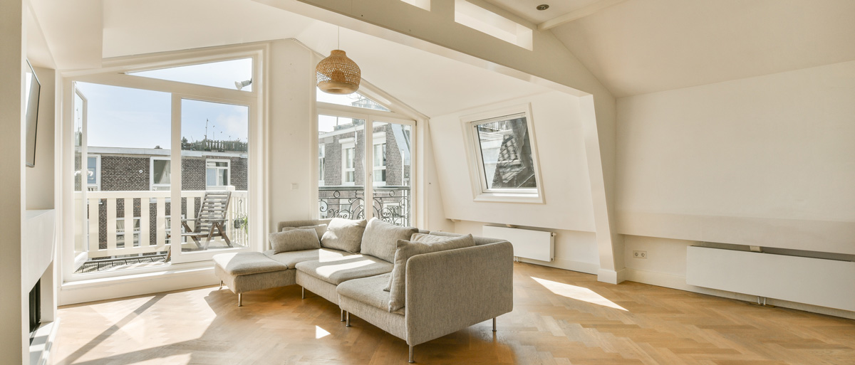 Salón moderno con ventanas panorámicas de gran formato que aportan luz natural y vistas urbanas