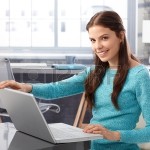 29562484-mujer-joven-feliz-utilizando-equipo-portatil-en-casa-abriendo-la-cubierta